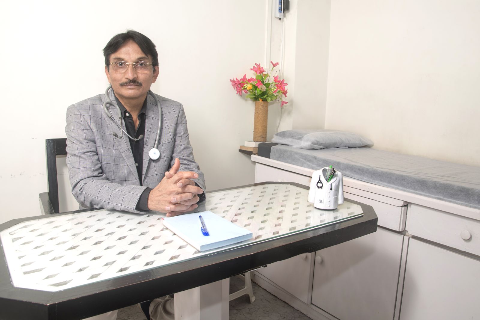 Dr. Santosh Gujarathi at his consulting desk in the Panchavati clinic